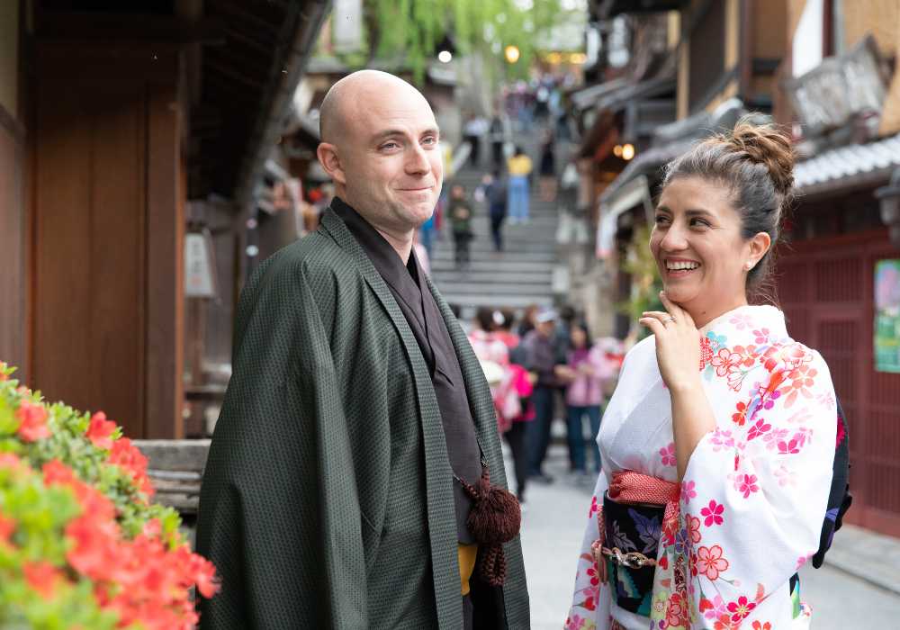 A man and woman in kimono standing in a narrow alley.
