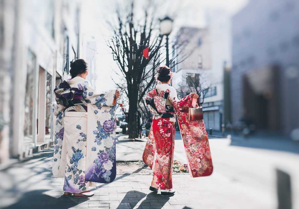 Two women in kimono walking down the street.