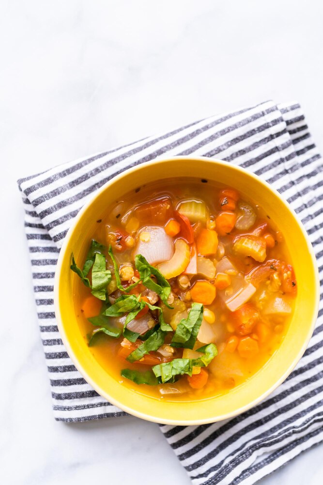 An illustration of a woman in traditional Japanese clothing eating soup with chopsticks, with a bowl of vegetables beside her and informative text about starting meals with soup.