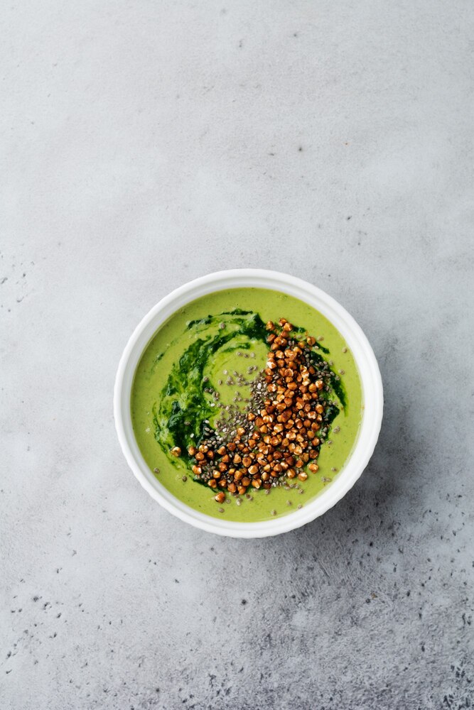 A bowl of soup topped with sesame seeds, a small dish of soy sauce, and chopsticks are arranged on a wooden tray on a tatami mat.